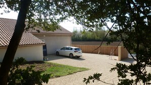A residential property with a white car parked in a driveway, a house with a tiled roof, and a fenced yard. - Le232 fr Meublé 4 Personnes Draps, Serviettes et Ménage Inclus (Chasseneuil-du-Poitou)