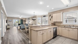 A spacious kitchen with a large island, beige cabinetry, and a dishwasher. - Three Bedroom Resort Condo close to Golf, Beach, Shopping & Popular Attractions (Myrtle Beach)