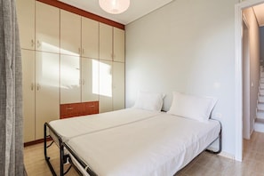 Ein Schlafzimmer mit einem Bett, einem Kleiderschrank und einer Treppe.