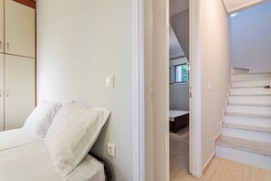 Ein Schlafzimmer mit Bett, Kleiderschrank und einer Treppe zu einem anderen Raum.
