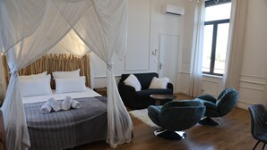 A bedroom with a four-poster bed, a sofa, two armchairs, and a small table. - La Romantique, luxury suite with bathtub at Château La Vidalle (Vendres)