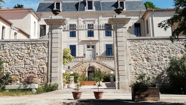 A historic building with a symmetrical facade, stone walls, and a central entrance with a staircase. - La Romantique, luxury suite with bathtub at Château La Vidalle (Vendres)