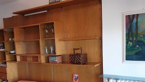 A living room with a wooden shelving unit, a sofa, and a table. - appartamento luminoso  con balcone, silenzioso davanti a un parco vicino a GYM (Gallarate)