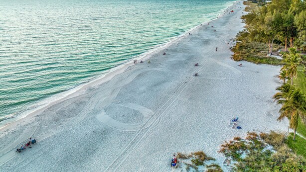 A beach with a clear view of the ocean and a sunset in the background. - Chic Pool Home Steps to Beach! Game Room and Paddleboards (Holmes Beach)