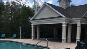 A swimming pool with lounge chairs and a covered pavilion. - Venetian Bay Townhome 3 Bedroom Townhouse by RedAwning (Kissimmee)