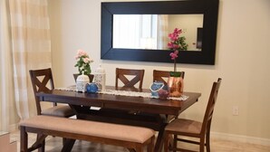 Une table à manger avec quatre chaises, un banc et un chemin de table en dentelle.