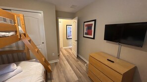 A room with a bunk bed, a TV mounted on the wall, and a wooden dresser. - Paradise Palms-4 Bedroom Townhome-3001PP 4 Townhouse by RedAwning (Kissimmee)