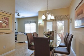 A dining area with a table, chairs, a chandelier, and a ceiling fan. - Paradise Palms-4 Bedroom Townhome-3001PP 4 Townhouse by RedAwning (Kissimmee)
