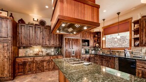 Una cocina amplia con gabinetes de madera, encimera de granito y una isla grande.