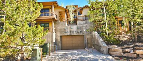 Stunning multi-story building with a prominent entrance, featuring a balcony and a garage door.