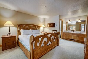 Un dormitorio con cama de madera, mesitas de noche y un espejo grande.