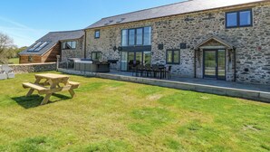 A stone building with a flat roof, large windows, and a patio area with a picnic table. - Bwthyn Y Bugail (shepherd's Cottage (Oswestry)