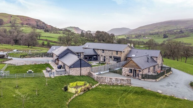 A stone building with multiple rooms, a fenced yard, and a view of rolling hills. - Bwthyn Y Bugail (shepherd's Cottage (Oswestry)