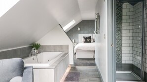A modern bathroom with a bathtub, shower, and glass-enclosed shower area. - 6 Lock View (Skipton)