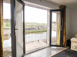 Una habitación con puerta de vidrio corrediza que da a un balcón con barandilla de metal.