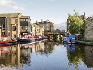 A canal with boats, stone buildings, and a bridge.