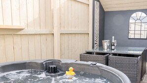 A hot tub with a rubber duck, a metal bucket, and a glass of wine on a table. - 6 Lock View (Skipton)