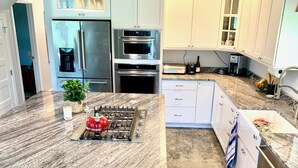 Una cocina moderna con una isla central, electrodomésticos de acero inoxidable y armarios de colores claros.