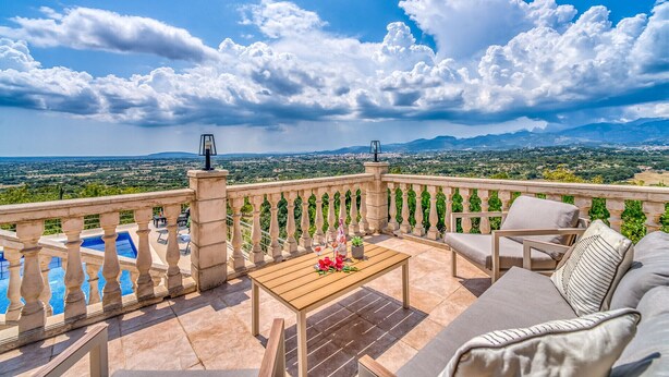 A balcony with a view of a cityscape and mountains, a pool, and outdoor furniture. - Finca with panoramic views Es Claperas in Mallorca (Inca)