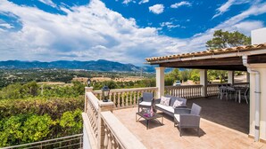 A covered outdoor seating area with wicker furniture and a view of the countryside. - Finca with panoramic views Es Claperas in Mallorca (Inca)