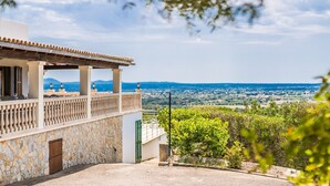 A building with a stone facade, a balcony with a balustrade, and a view of a distant landscape. - Finca with panoramic views Es Claperas in Mallorca (Inca)