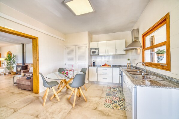 A modern kitchen with white cabinets, a microwave, and a large window. - Finca with panoramic views Es Claperas in Mallorca (Inca)