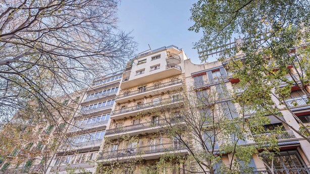 A multi-story building with balconies, surrounded by trees. - Sweett | Rocafort Principal 3 (Barcelona)