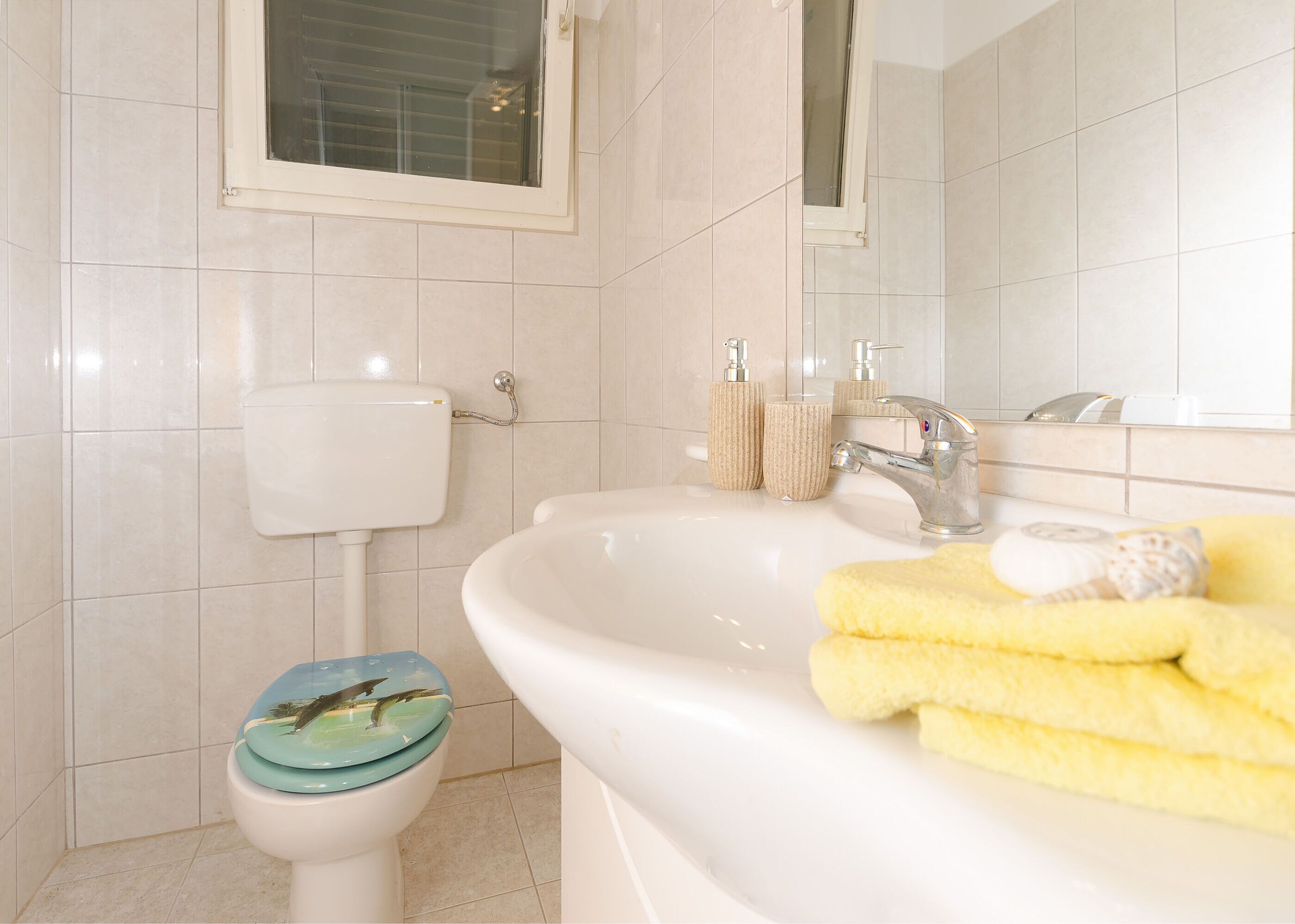 Un baño con inodoro, lavabo y espejo.