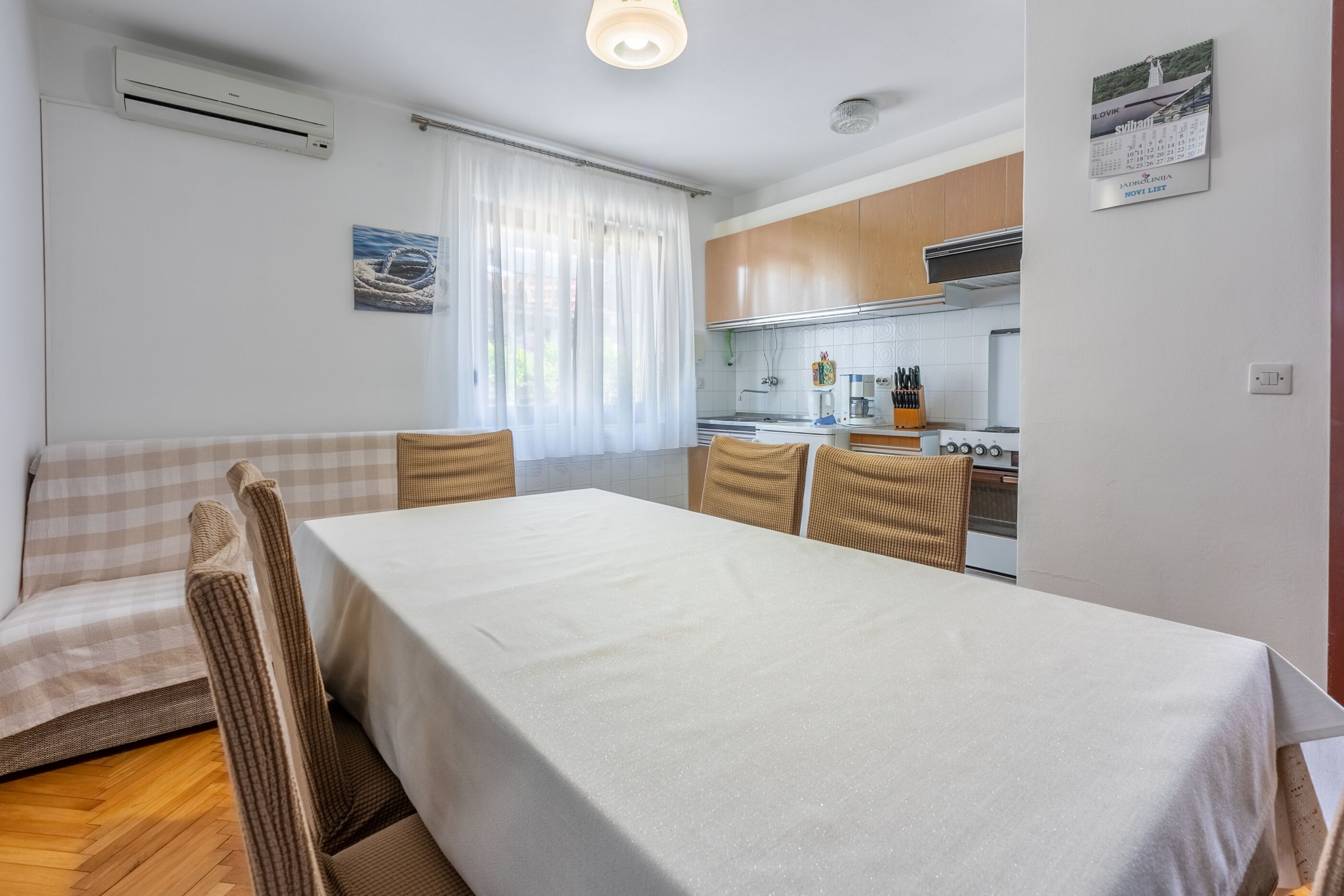 Ett kompakt bostadsutrymme med ett matbord, en soffa och ett litet kök.
