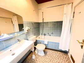 Un baño con bañera, inodoro y lavamanos.
