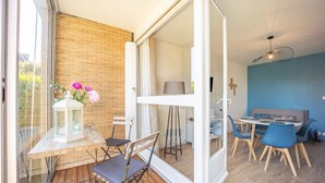 Un espace de salle à manger moderne, avec une table et des chaises, une vue à travers une porte vitrée et un ventilateur de plafond.