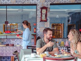 Un comedor con una pared con diseño, un reloj y una ventana con vistas.
