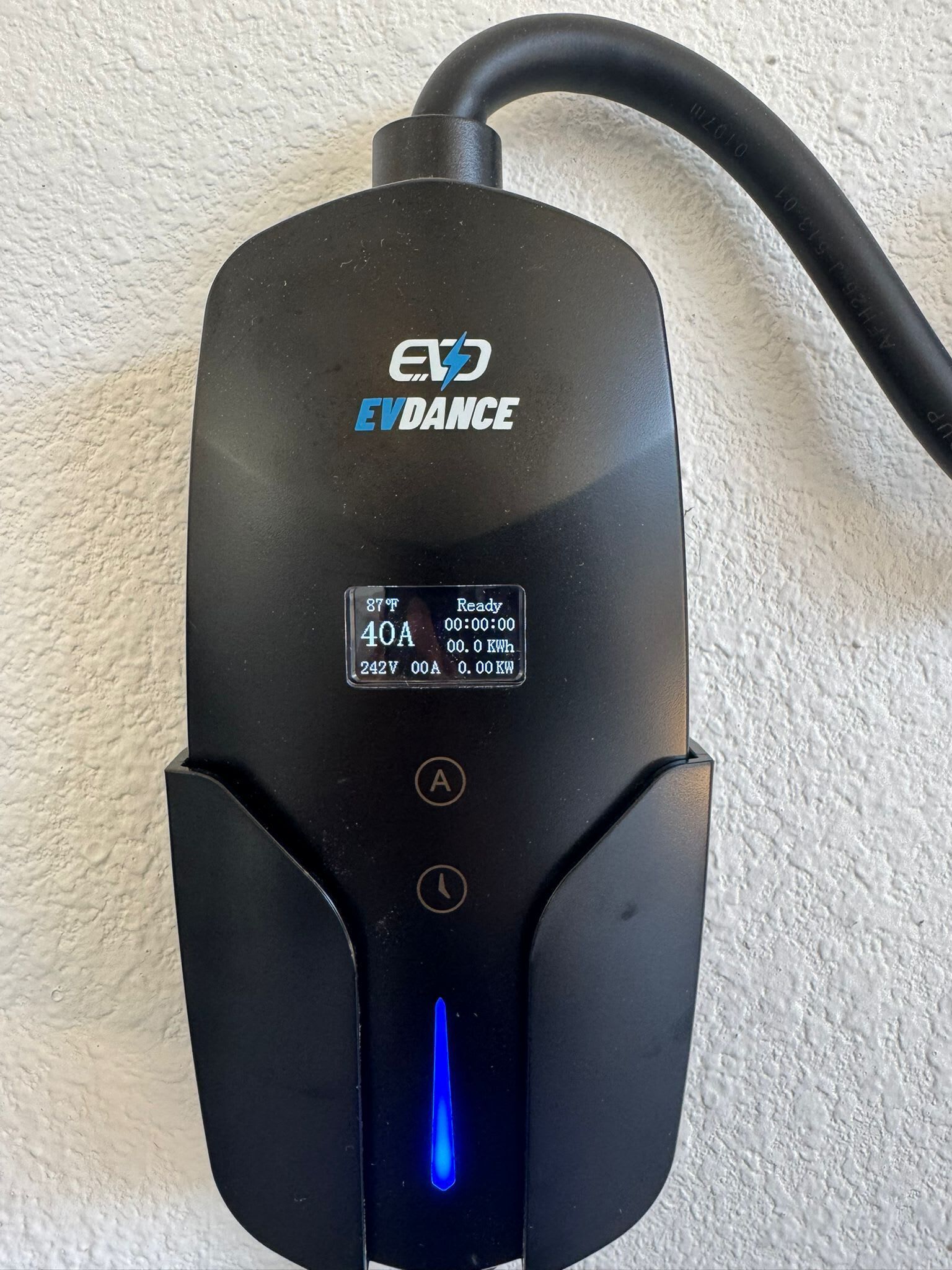 Een zwarte EV DANCE laadstation met een digitaal scherm dat 87°F, 40A, 242V, 0,0 kWh en 0,0 kW aangeeft.