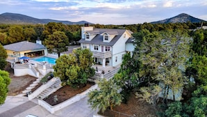 A large house with a pool, surrounded by trees and mountains. - East Wing - Exquisite Mountain Estate with Pool (Silver City)