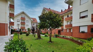 Un patio central con un árbol, rodeado de edificios con balcones y ventanas.