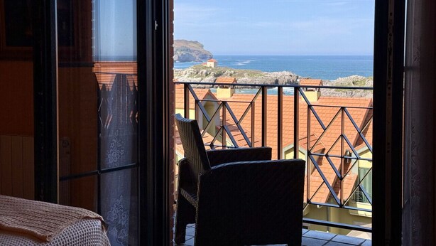 Un balcone con vista sull'oceano e sugli edifici.