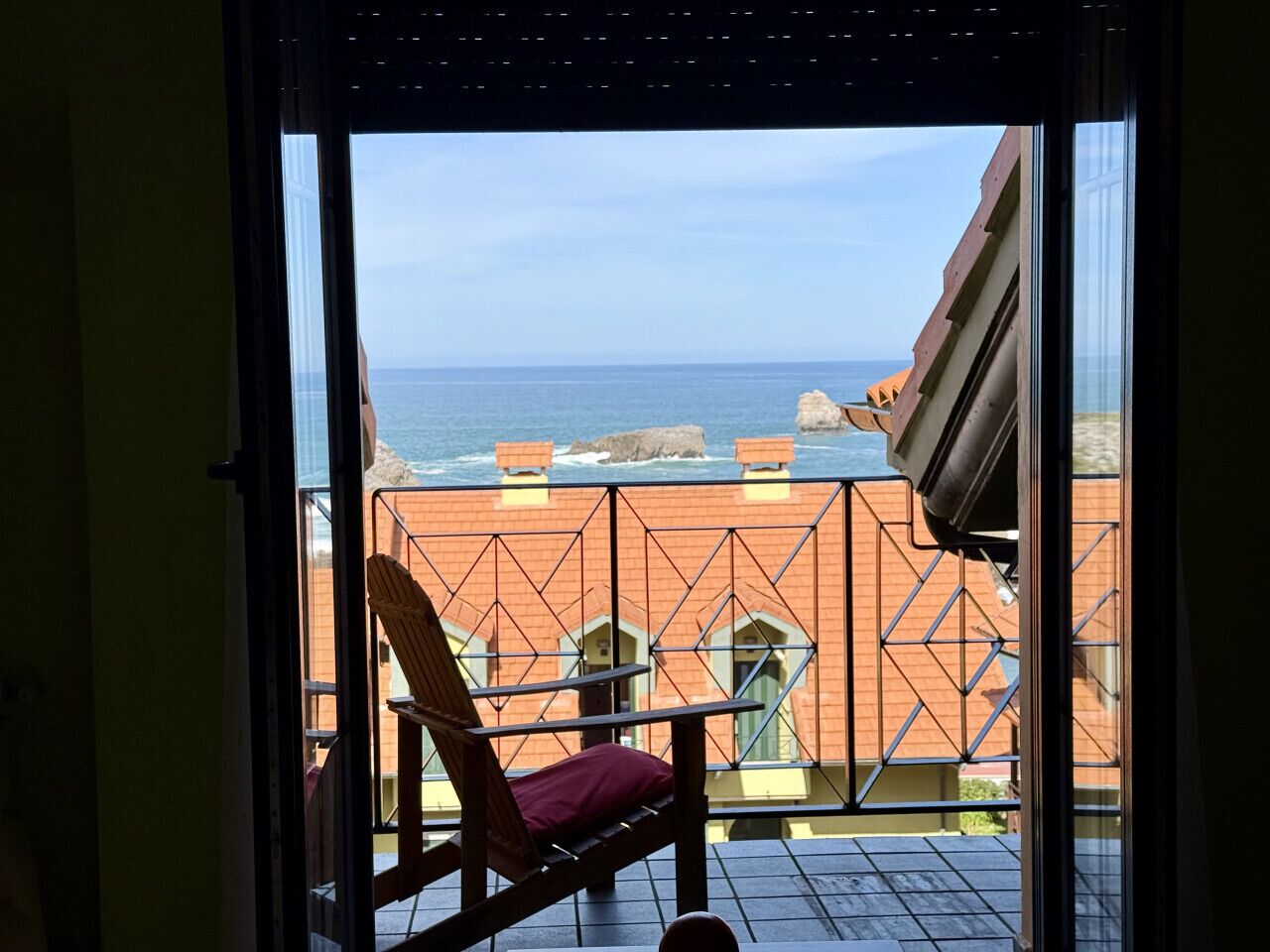 Een balkon met uitzicht op zee en gebouwen.