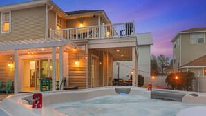 A house with a hot tub and a covered patio area. - Beach+Pool+Hot Tub |  Golf Cart(incl) + Game Room (Destin)