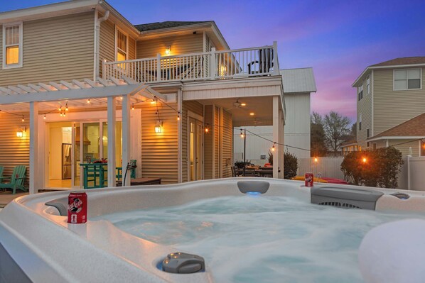 A house with a hot tub and a covered patio area.