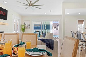 A dining area with a table set for breakfast, including plates, glasses, and a pitcher of orange juice. - Beach+Pool+Hot Tub |  Golf Cart(incl) + Game Room (Destin)