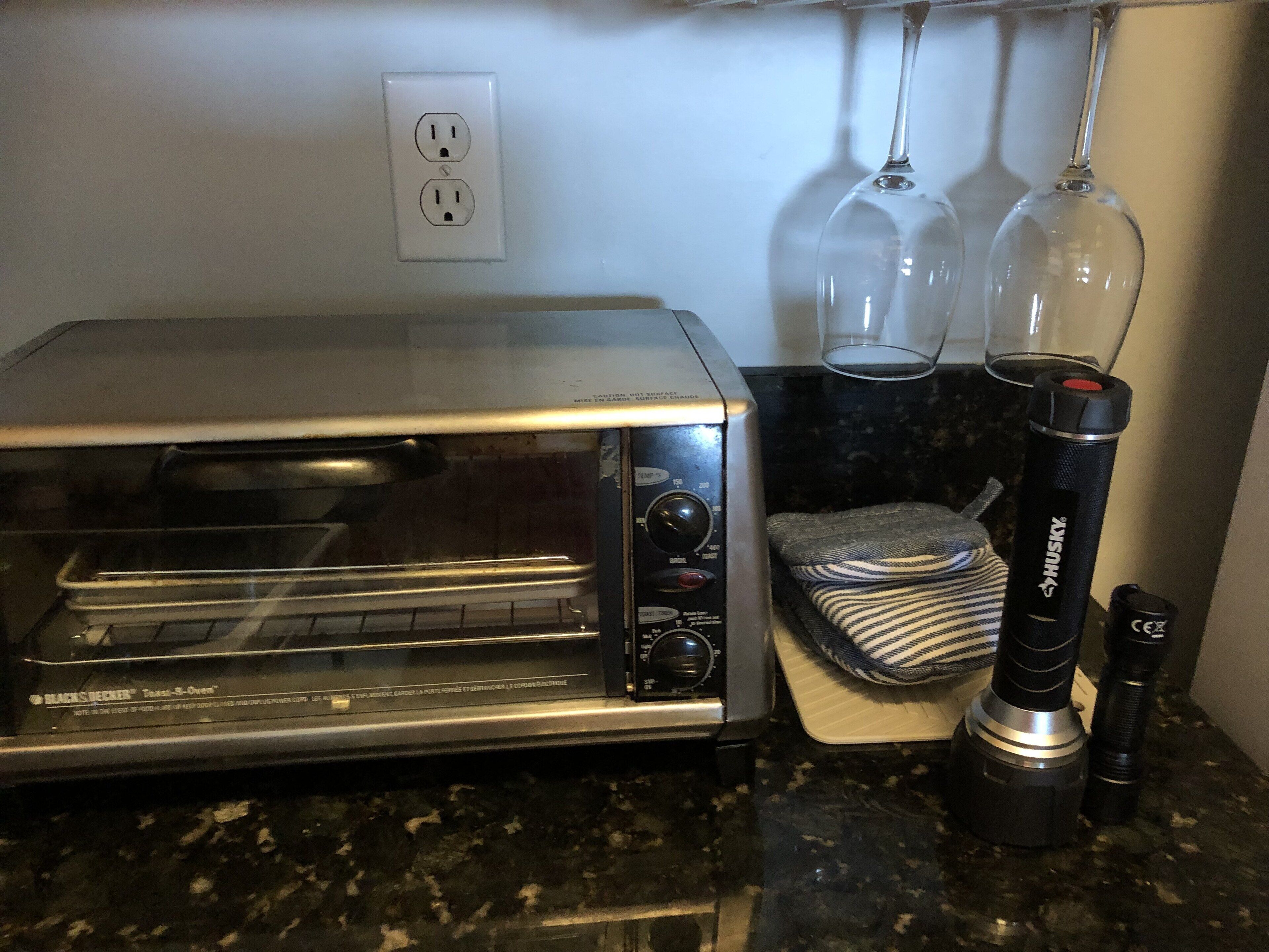 A kitchen with a toaster oven, a blender, and a kettle on the counter.