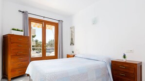 Une chambre à coucher avec un lit, une commode en bois et une table de chevet.