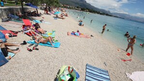 A crowded beach with people sunbathing and swimming, surrounded by mountains. - Modern apt in the Stone House in the Very Center (Kastela)