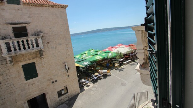 A view of a coastal street with outdoor seating and a clear view of the sea. - Modern apt in the Stone House in the Very Center (Kastela)