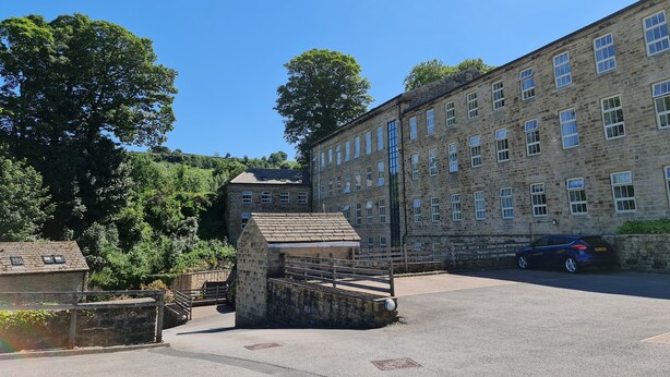 A stone building with multiple windows and a paved courtyard. - 2 Bed Woodland Retreat - Garden & Free Parking (Keighley)