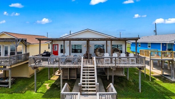A beachfront property with multiple wooden decks and a central building with large windows. - Private Beach Walkover, Sunset Views & Room to Gather (Surfside Beach)