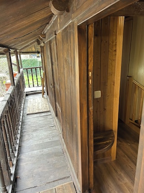 A wooden corridor with a wooden door and a small step leading into a room.