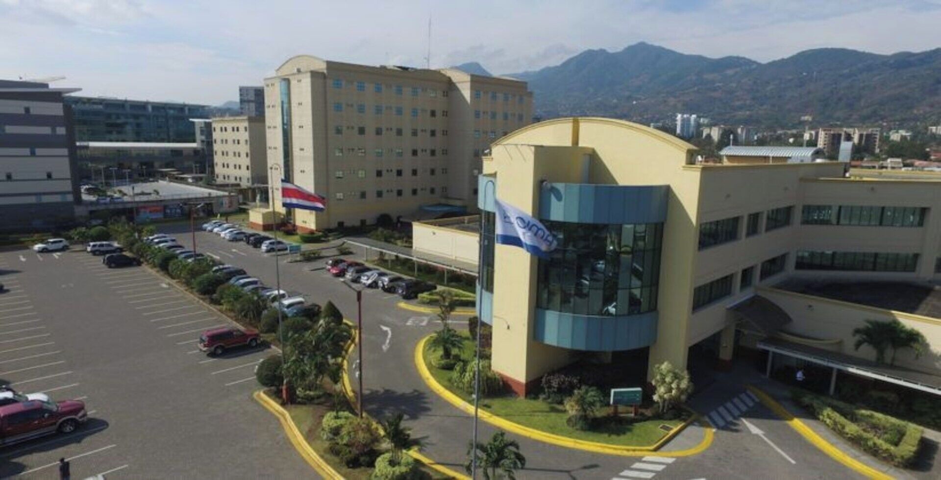 A multi-story building with a parking lot in front.