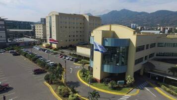 A multi-story building with a parking lot in front.