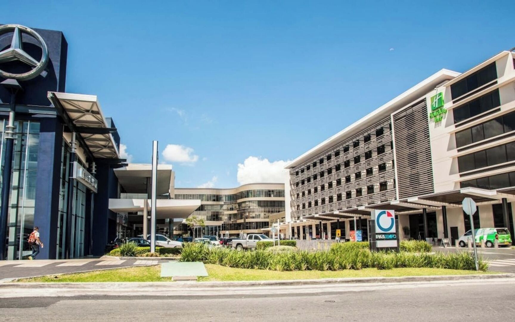 Een modern gebouw met een parkeergarage en een bord met Holiday Inn Express erop.